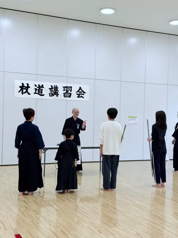 杖道講習会にて、笑顔で語り合う地域の先生と部員たち